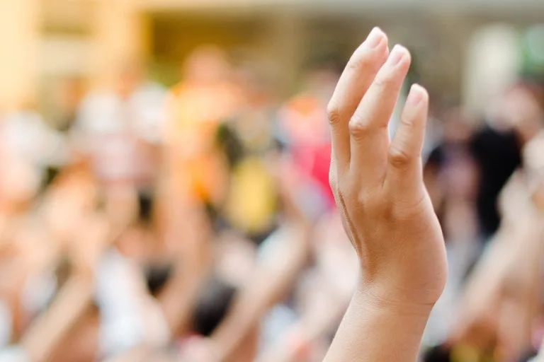 A hand raised in a crowd